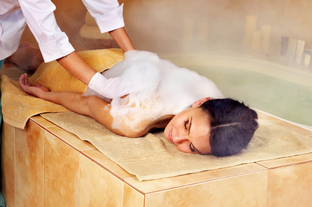 Junge Frau im Hammam oder türkischen Bad. Dampf im Badezimmer.
